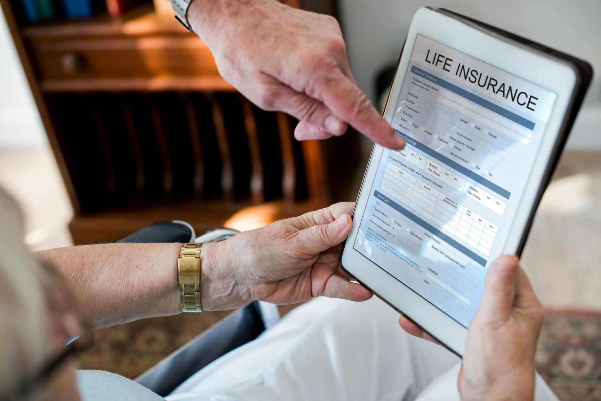 Person explaining life insurance details on a tablet to a client